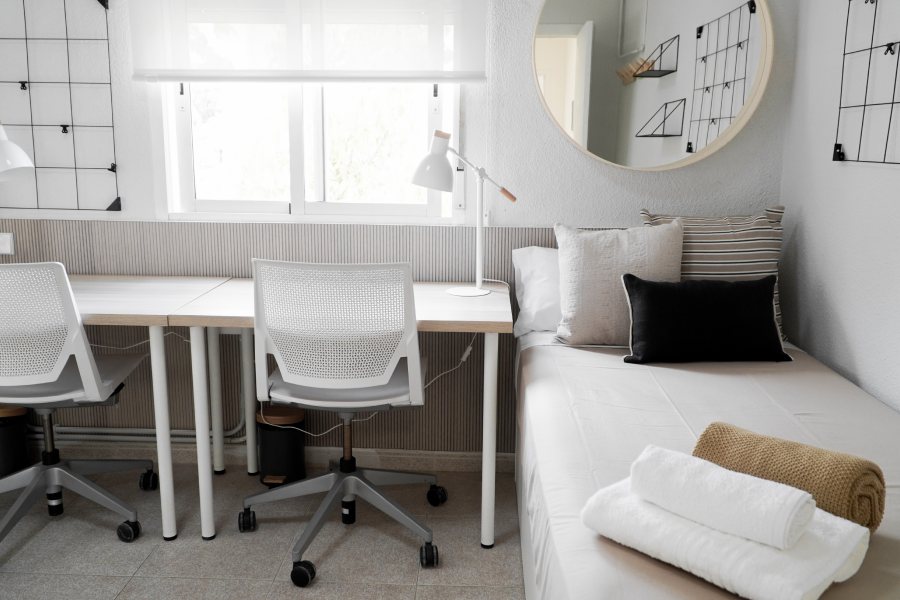 White Student room from the global college residence with two chairs, a table and a bed